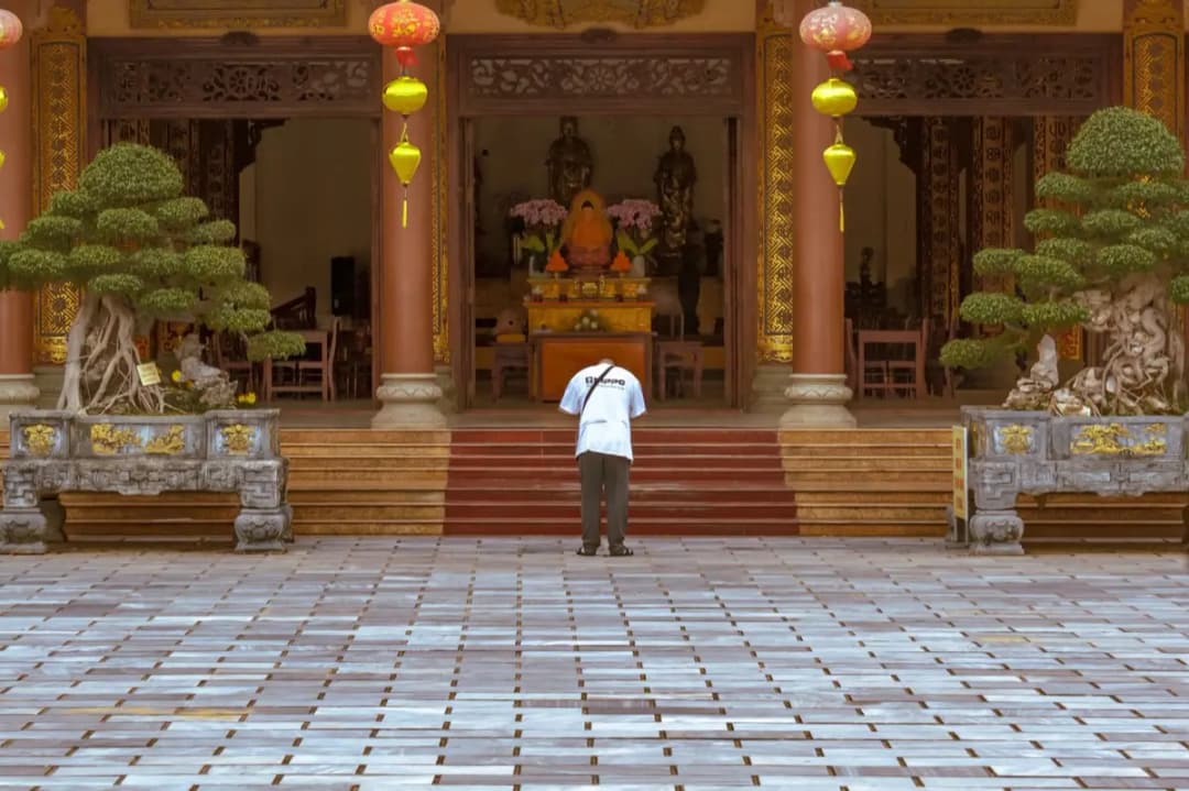 คนนั่งไหว้พระคนเดียวหน้าโต๊ะหมู่บูชาเล็กในบ้าน